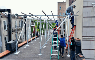 Kamtech Solar installation team building steel framing for commercial rooftop solar panels in New York, ensuring a durable and efficient setup.